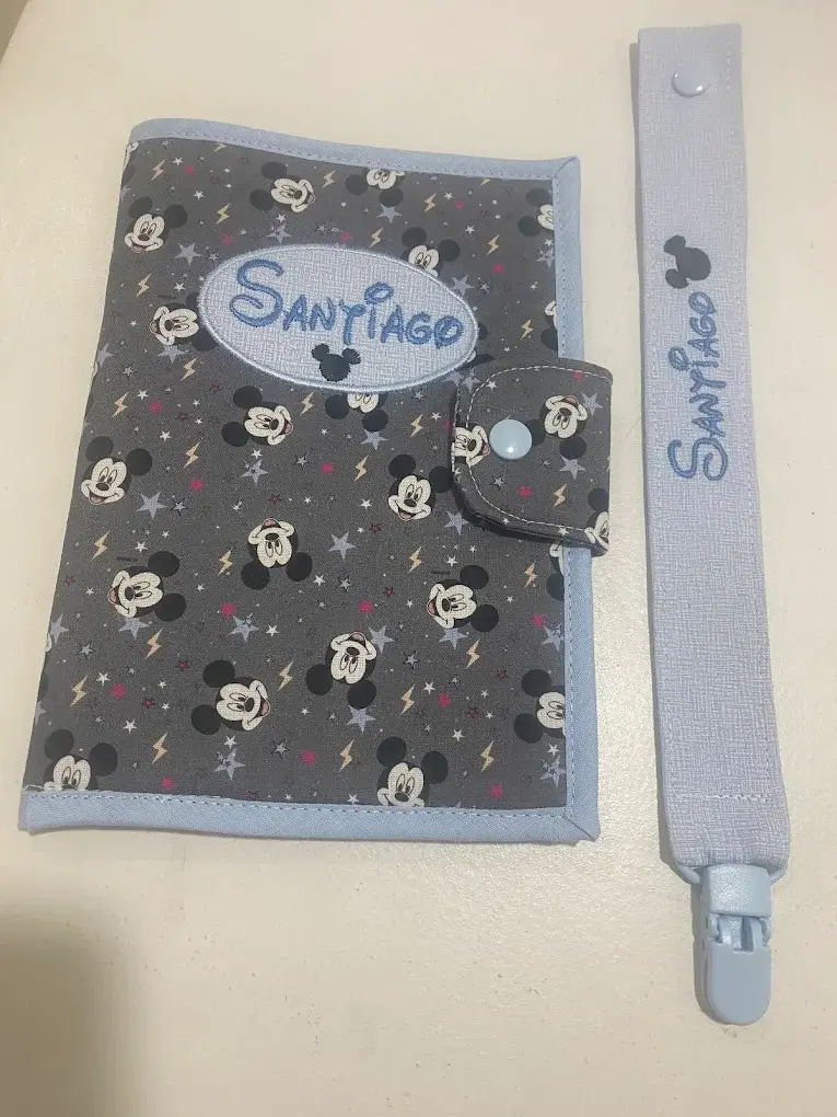 Capa em tecido cinzento do Mickey com o nome Santiago bordado e prendedor de chupeta a condizer.