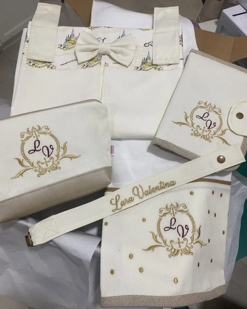 Conjunto marfim com monograma bordado a dourado.