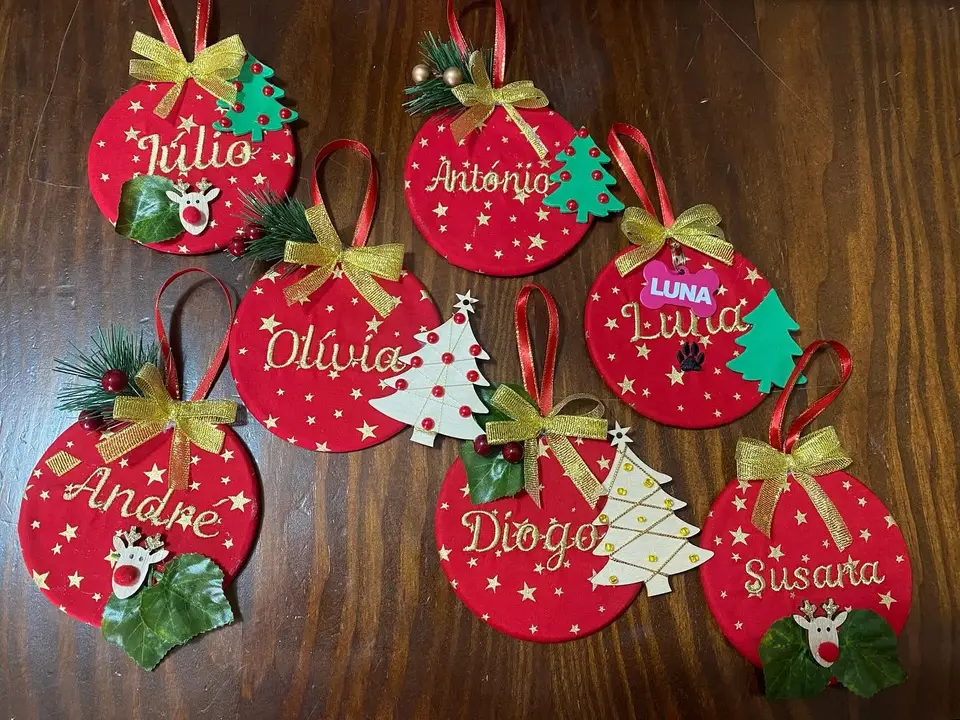 Enfeites de Natal vermelhos com nomes bordados.