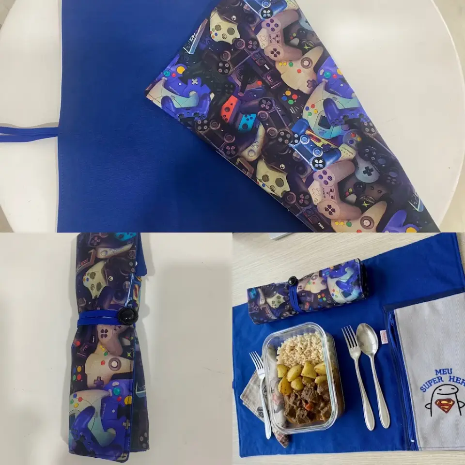 Porta-talheres de enrolar em tecido de comandos de jogos e individual azul, com a lancheira e os talheres.