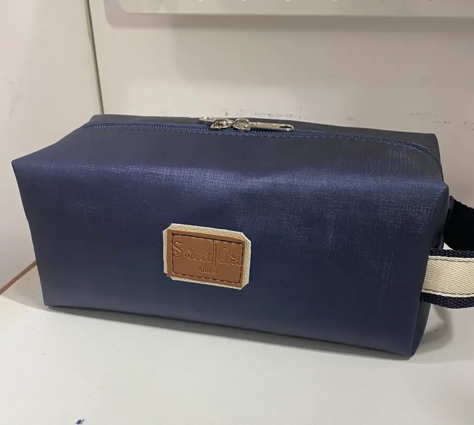 Necessaire azul-marinho com a etiqueta da Sweet Art cosida à frente.