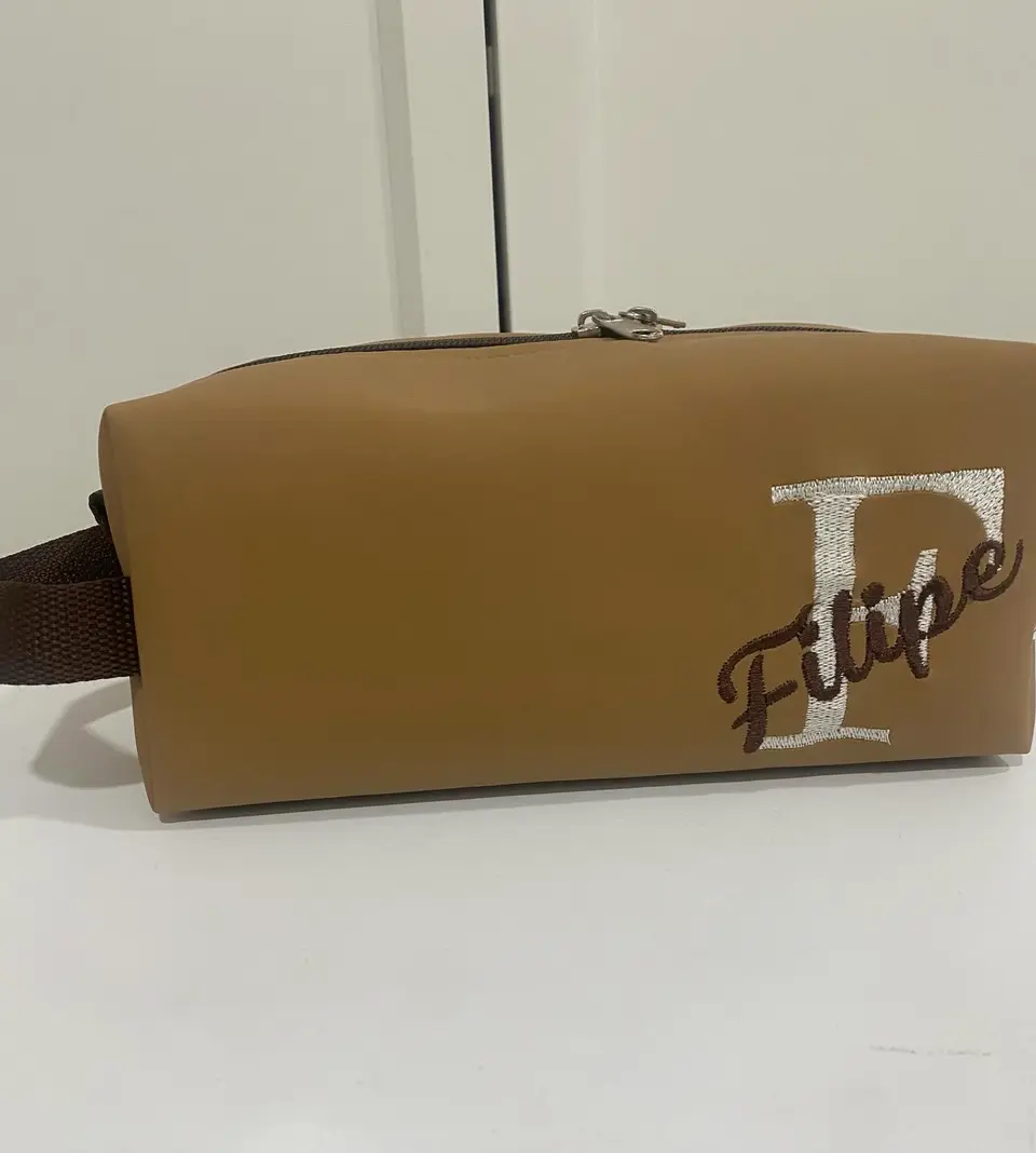 Necessaire caramelo com a inicial F e o nome Filipe bordados.