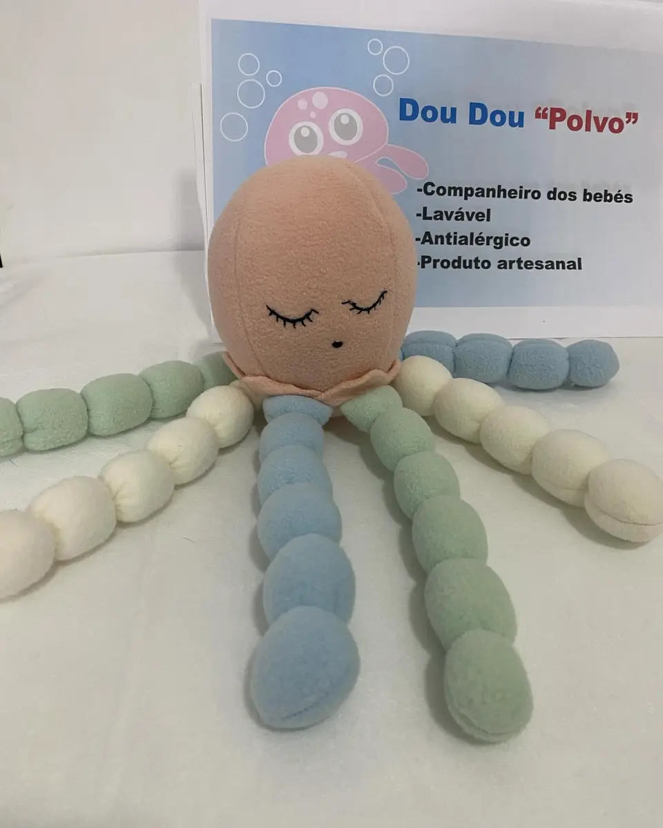 Polvo de pano cor de pêssego com tentáculos em verde, azul e branco.