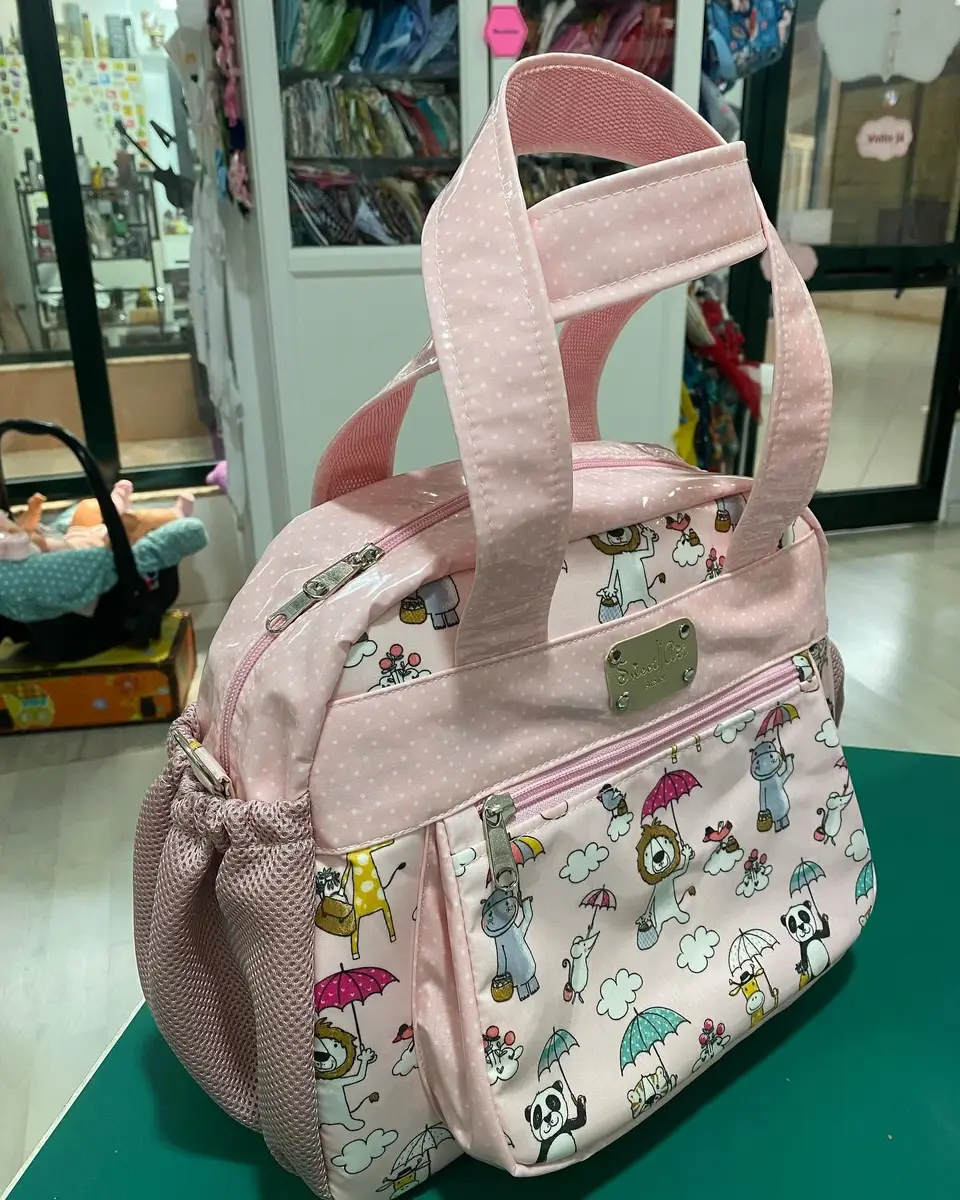 Saco de maternidade rosa com estampado de animais e alças em rosa.