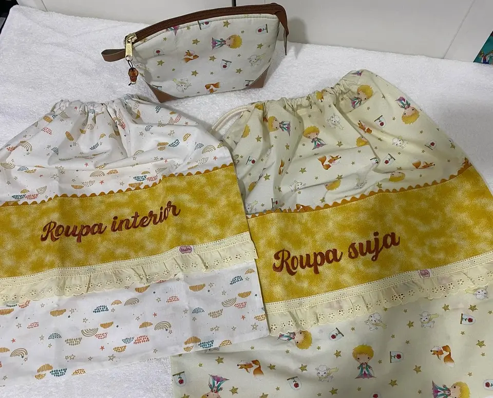 Dois sacos de roupa com as palavras Roupa interior e Roupa suja bordadas e uma necessaire a condizer.
