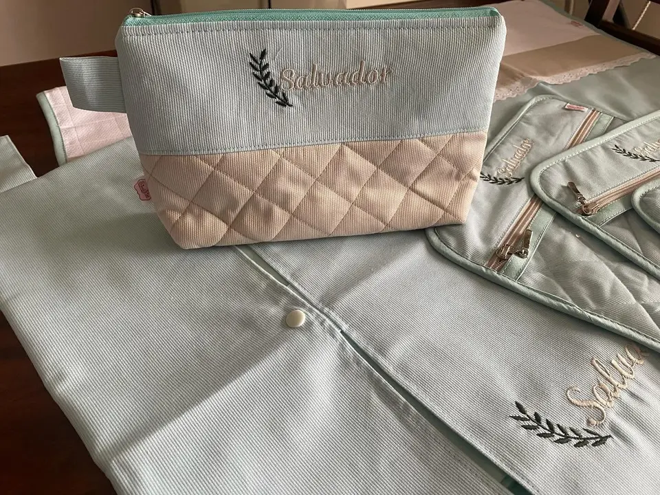 Necessaire com base acolchoada rosa-velho e o nome Salvador bordado com um raminho.